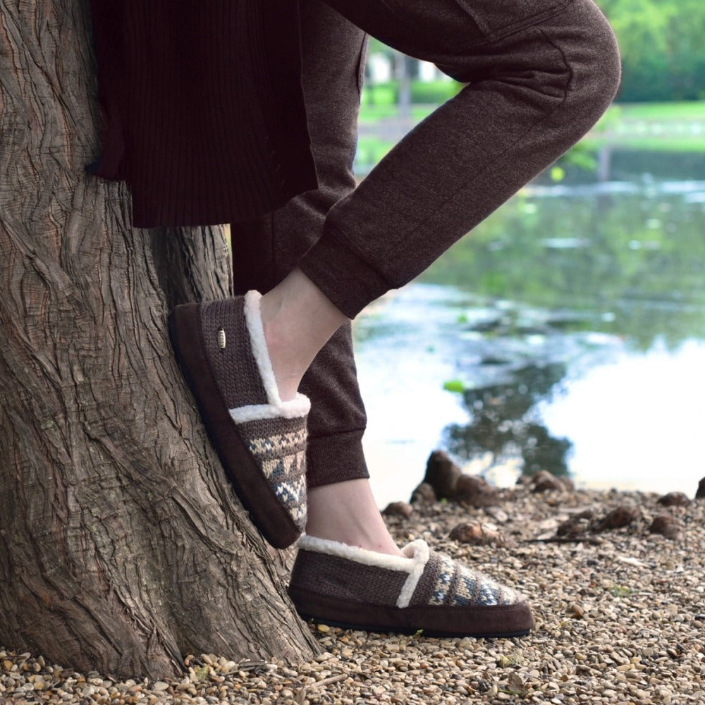 Women's Nordic Moccasins on figure standing against a tree outside by lake#color_nordic-brown