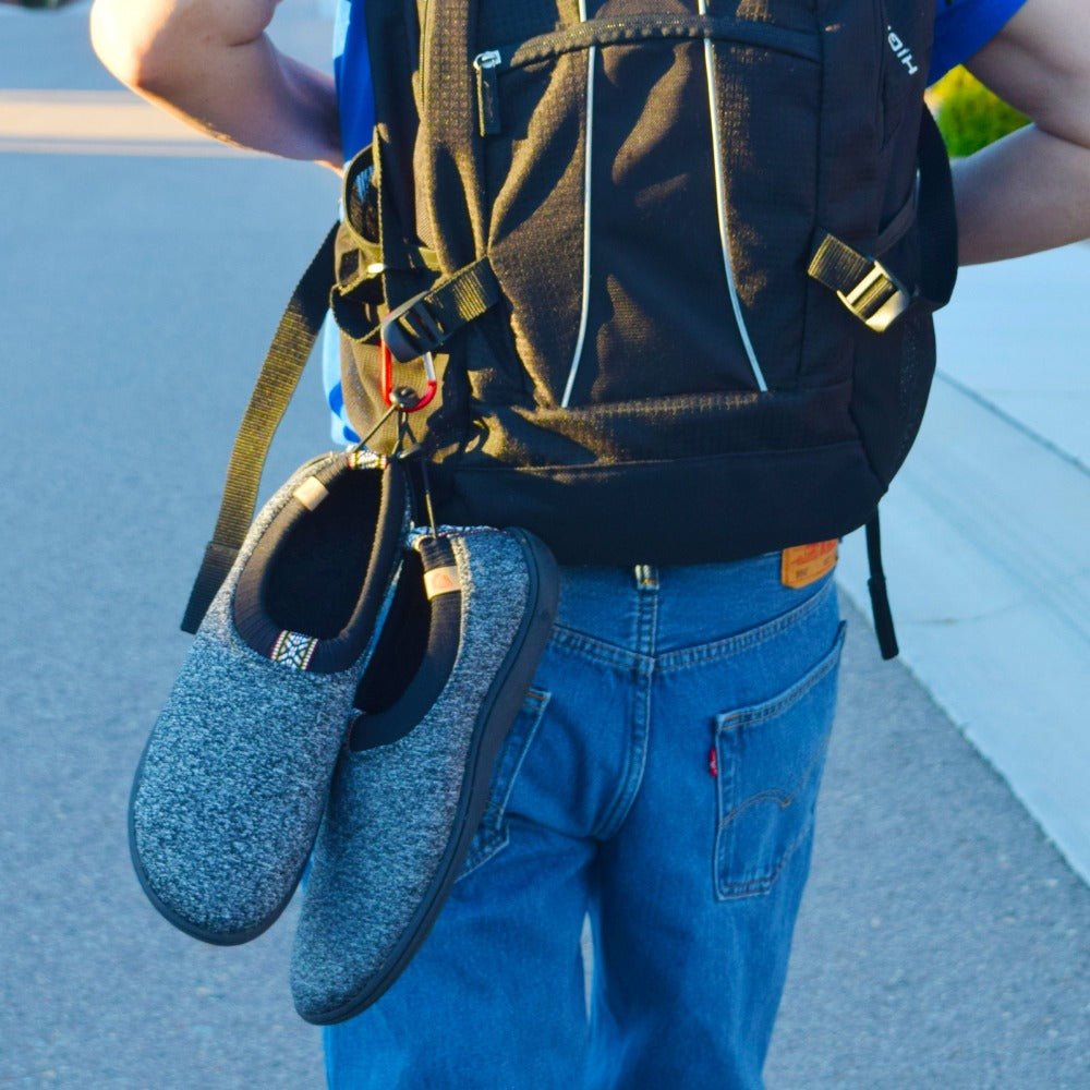 Acorn Explorer Adventure Moccasin hanging from men's backpack out on a city walk#color_black-heather
