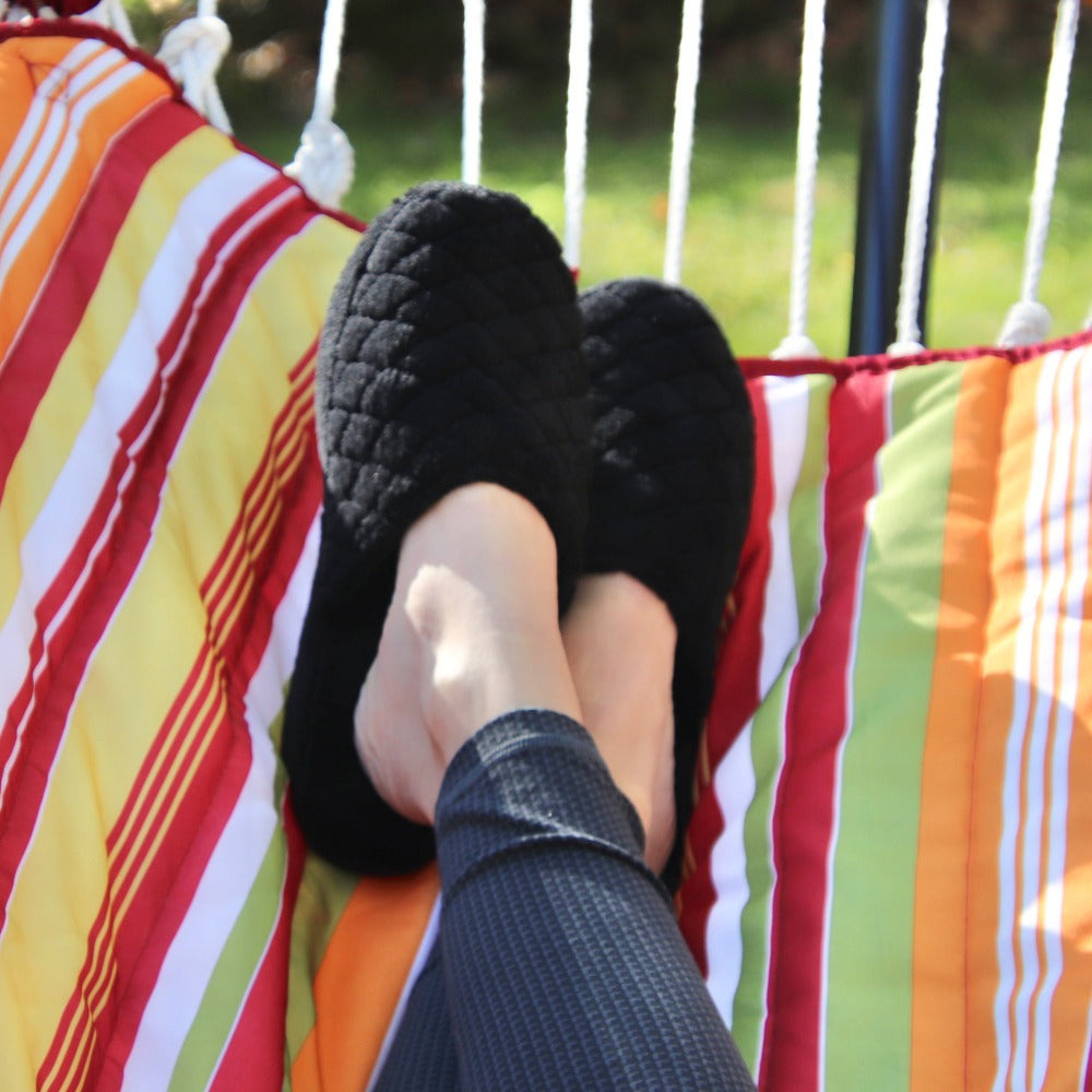 Women's Spa Quilted Clog in Black on figure. Model sitting in hammock, kicking back and relaxing#color_black
